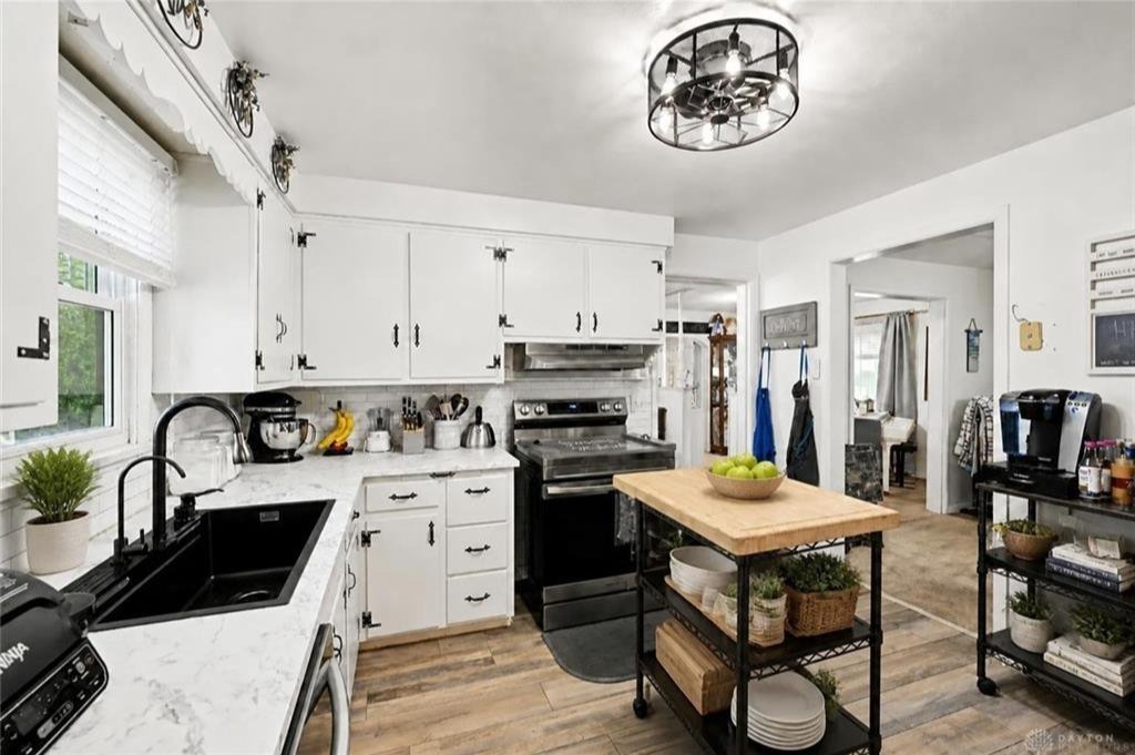 Updated kitchen with faux marble countertops and freshly painted cabinets